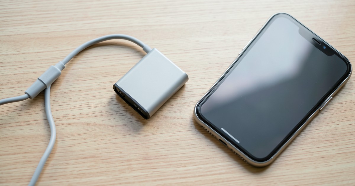 木製のデスクの上に置かれたスマートなモバイルバッテリーと充電ケーブル。